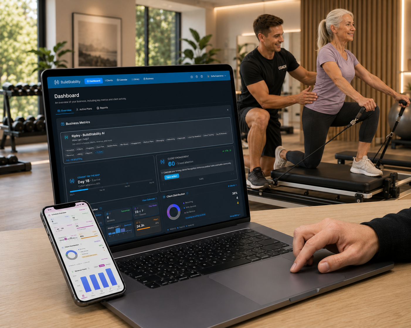 BuildStability dashboard on a MacBook with a coach training an older client on a reformer in the background